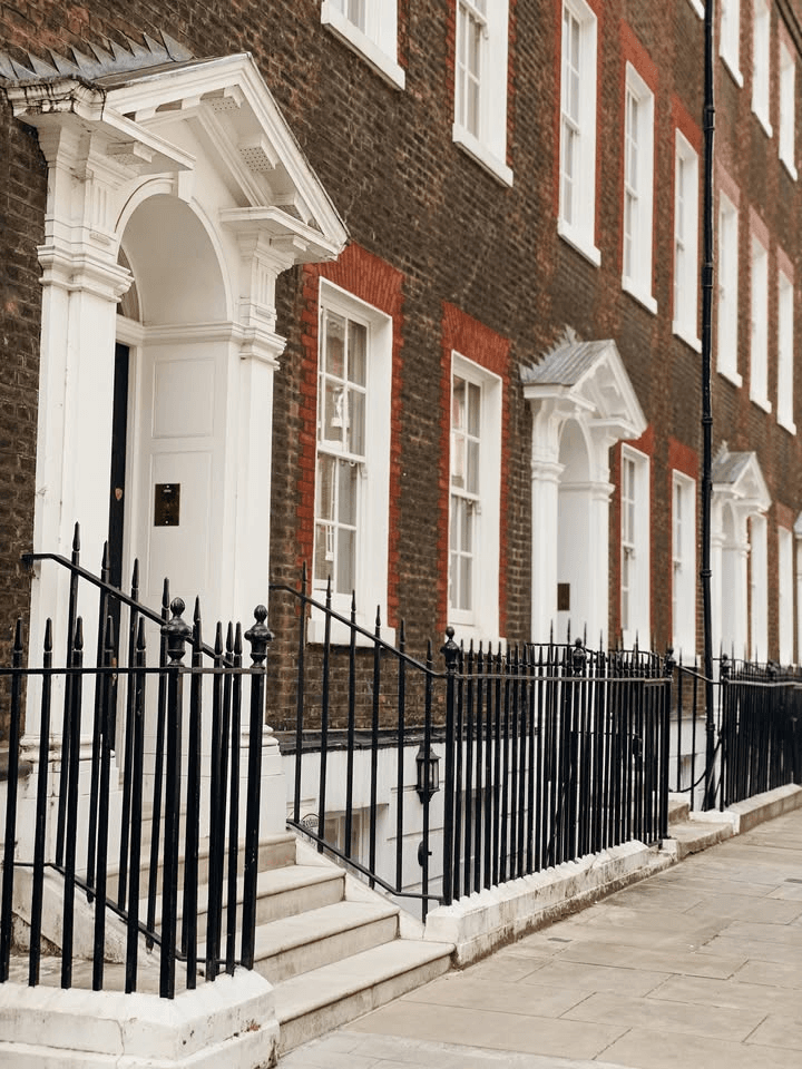 Westminster Georgian dark red brick townhouse with white Doric doorway columns and black iron railings