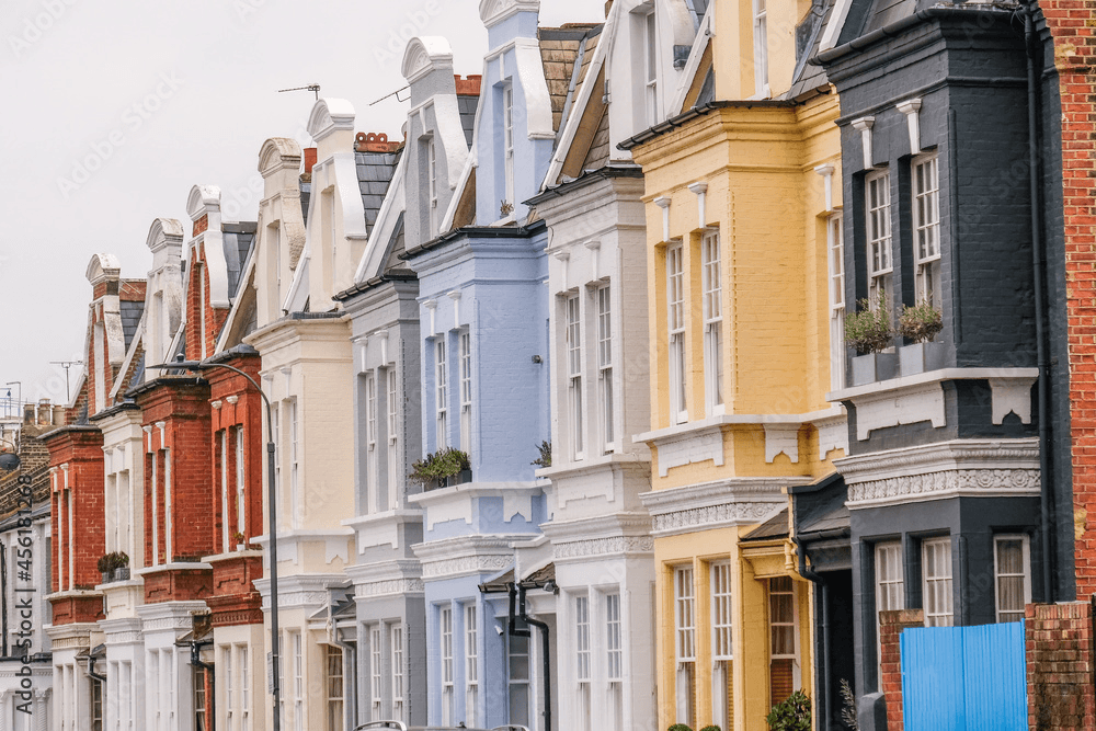 Row of colourful terraced houses in yellow, blue and grey on a Hammersmith residential street
